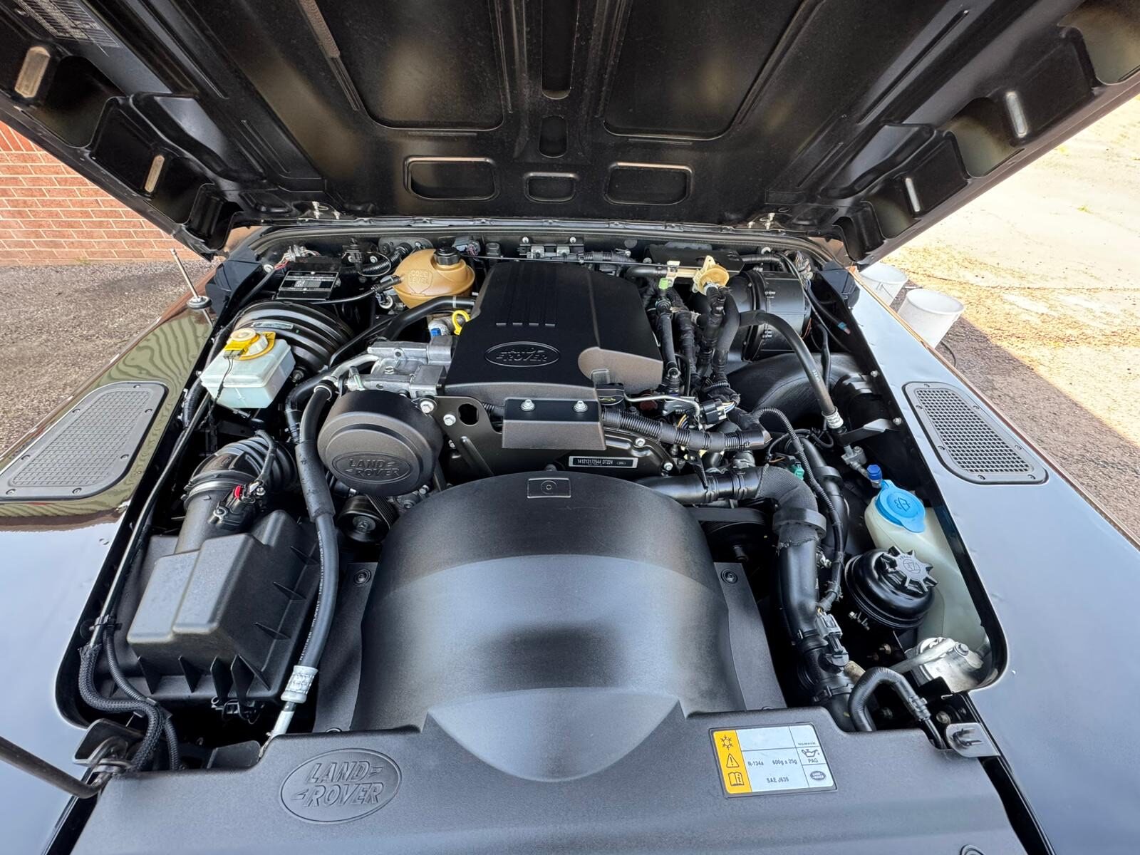 The same Land Rover Defender 90 engine bay after dry ice cleaning, with the original finishes left intact and no water used