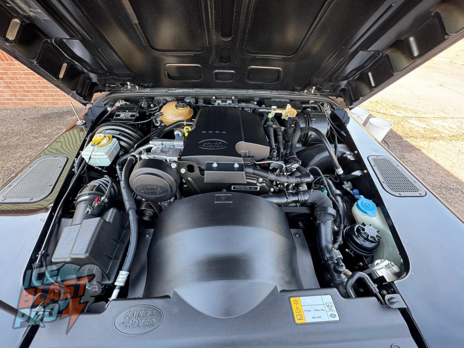 The same Land Rover Defender 90 engine bay after dry ice cleaning, with the original finishes left intact and no water used