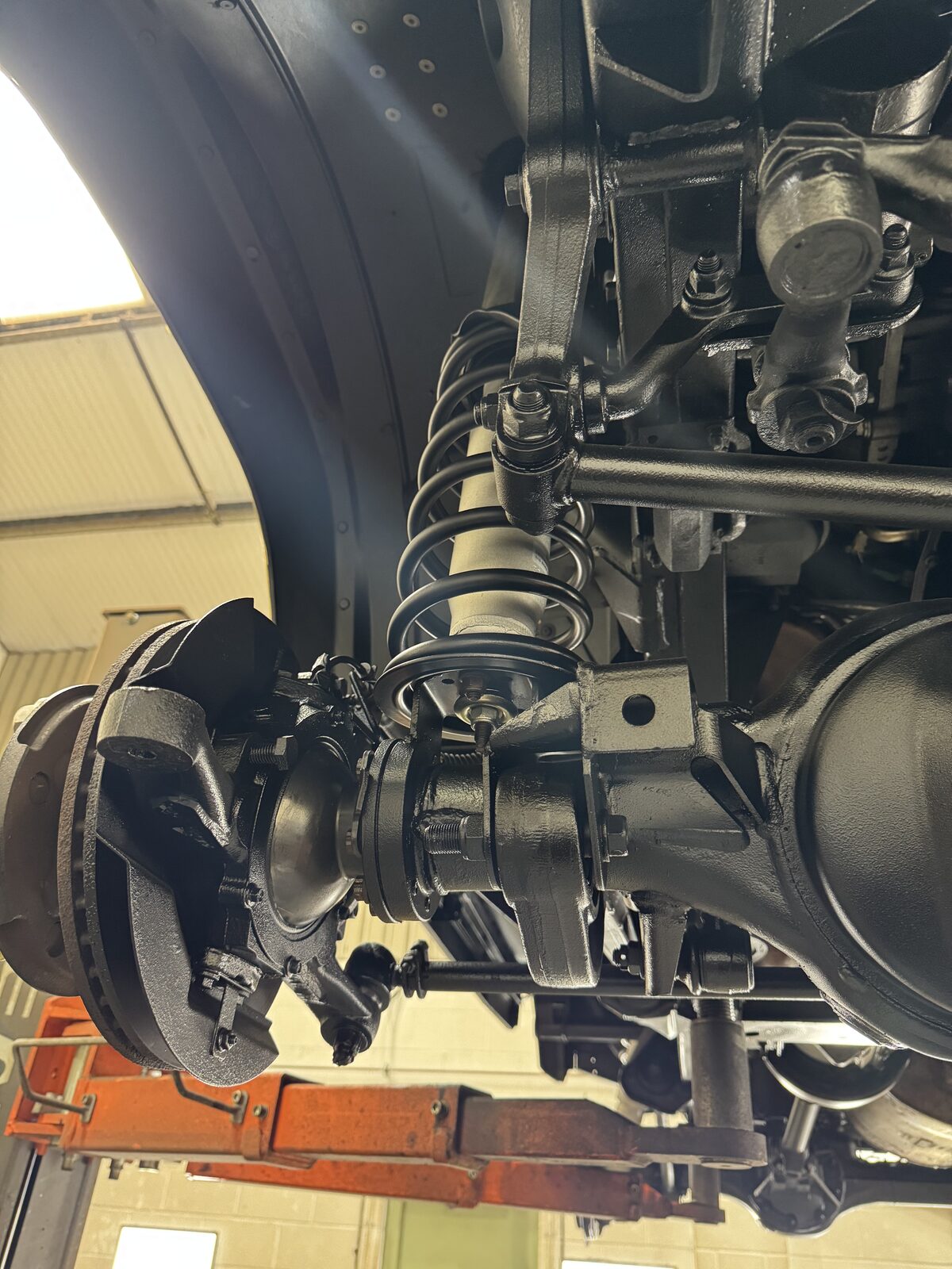 Front driver's side – Coil, hub and surrounding ironwork cleaned, treated and protected, with a consistent finish across the whole corner.