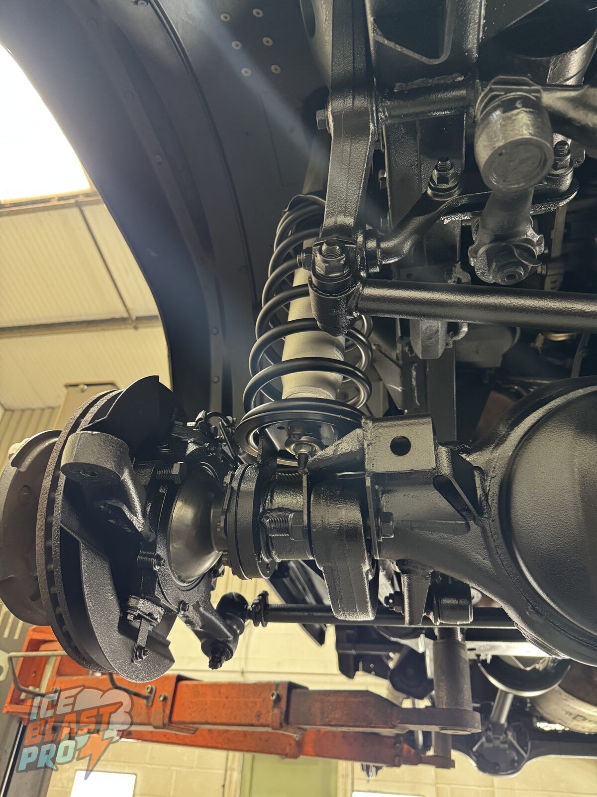 Front driver's side – Coil, hub and surrounding ironwork cleaned, treated and protected, with a consistent finish across the whole corner.