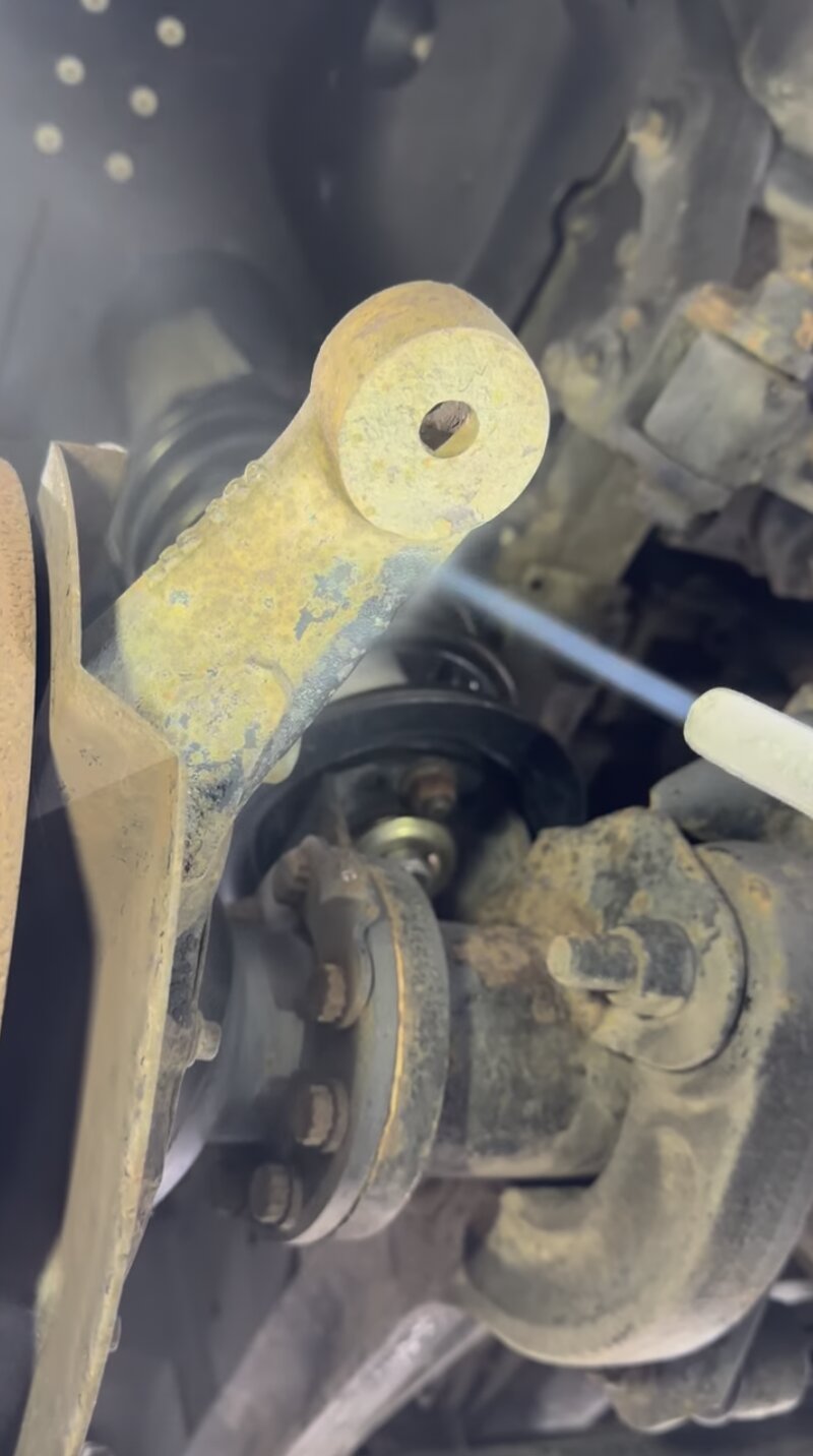 Test patch – front suspension – An early test blast on the front suspension, lifting grime and surface corrosion to reveal the condition of the metal underneath.