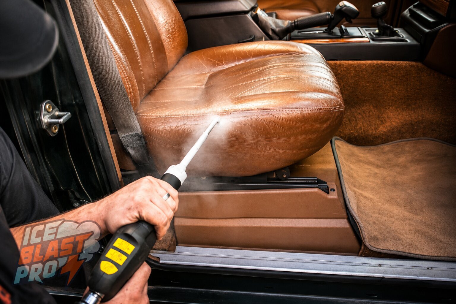 A handheld vapour tool cleaning the leather seat of a classic car's cabin.