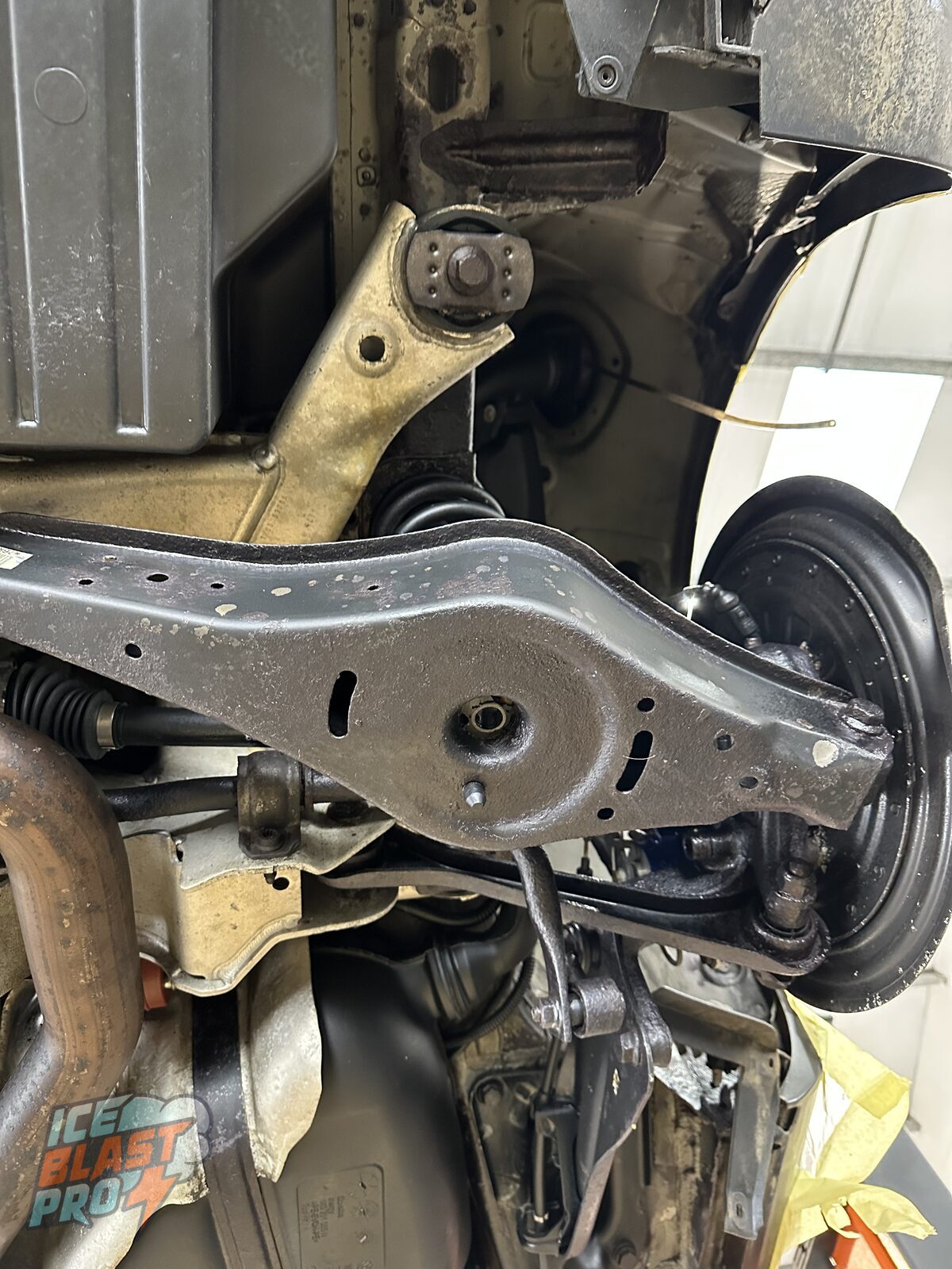 The same Golf R32 lower rear arm after dry ice blasting, rust treatment and a clear wax finish, with the surface corrosion gone and the metal sealed