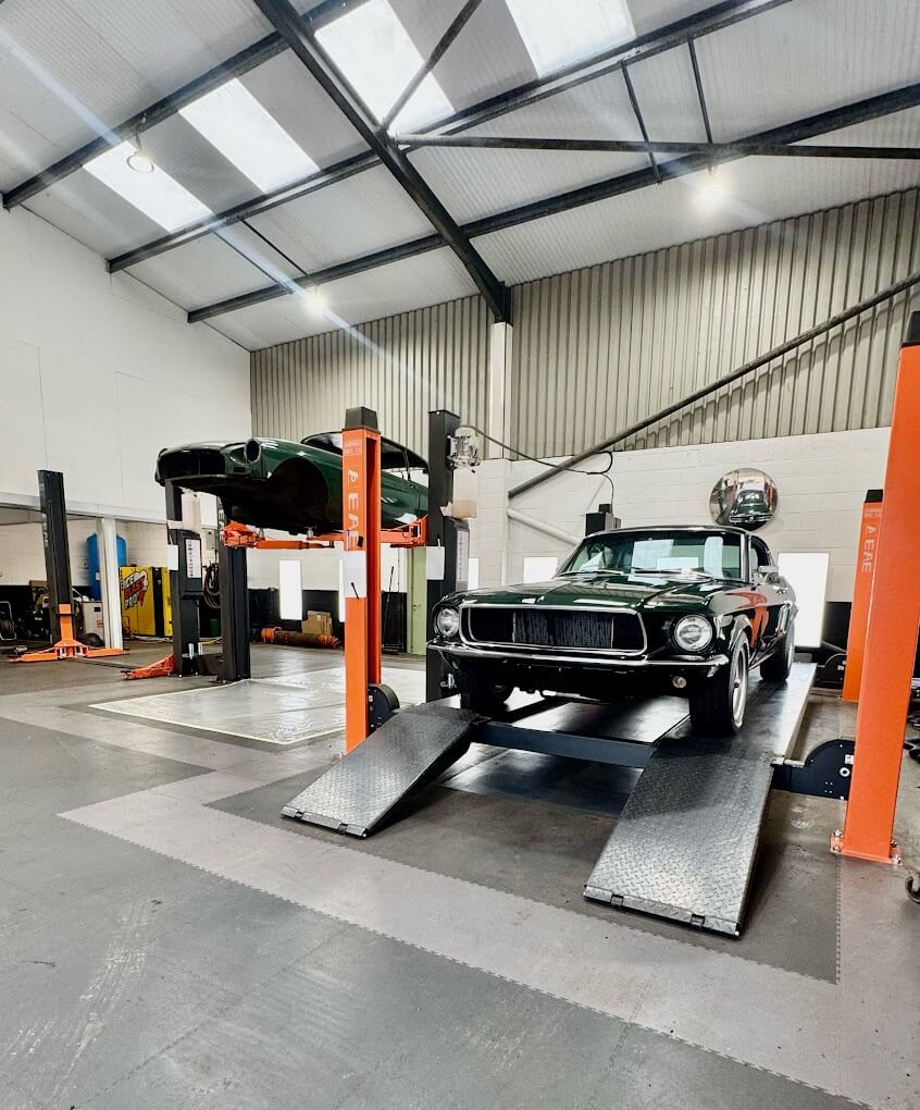 A classic vehicle raised on a ramp for underbody dry ice blasting at the IceBlastPro workshop in Oxfordshire, near the Cotswolds