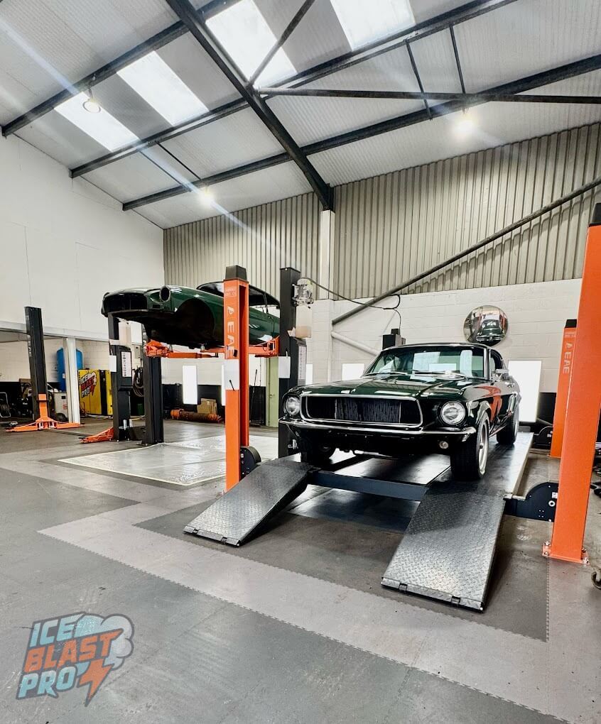 Classic cars on four-post and two-post ramps inside the IceBlastPro automotive dry ice blasting workshop in Oxfordshire