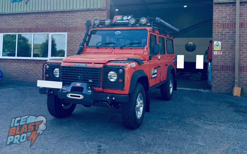 Red Land Rover Defender G4 Challenge outside the IceBlastPro workshop
