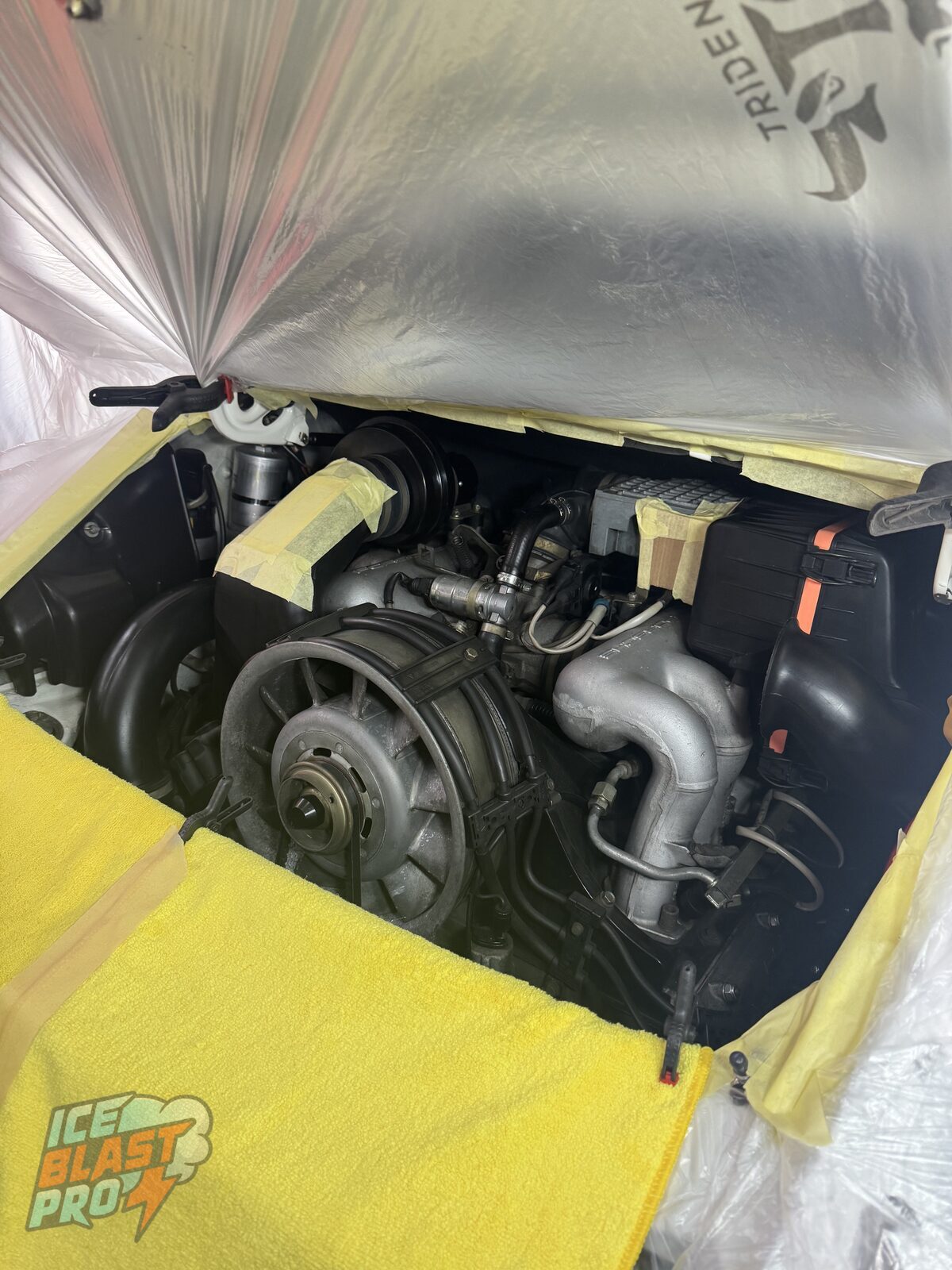 The Porsche 911 Carrera CS engine bay masked off with covers and tape, prepped and ready for dry ice cleaning