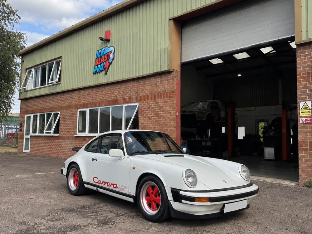 White Porsche 911 Carrera CS with red wheels outside the IceBlastPro workshop