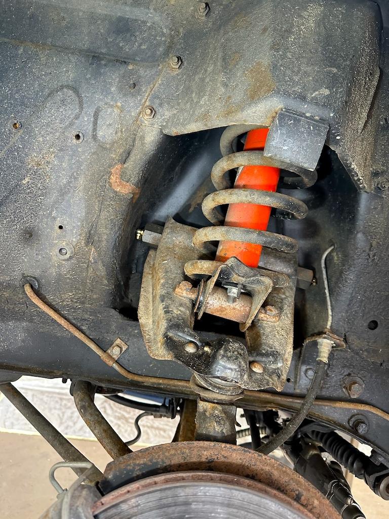 Front coil & shock – Coil, shock area and corroded disc shield. Original red shock to stay clean – clear wax around it, not over it.