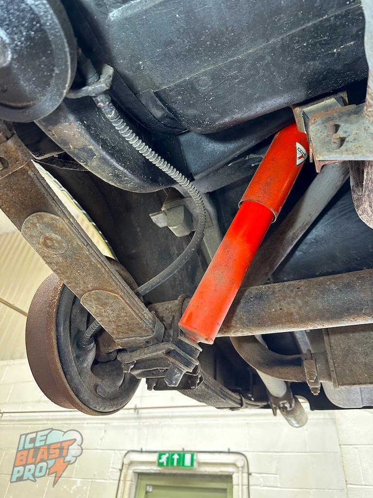 Rear leaf springs & shocks – Surface corrosion across the leaf spring and mounting bracket. Brake drum showing oxidation. Shock paint good.