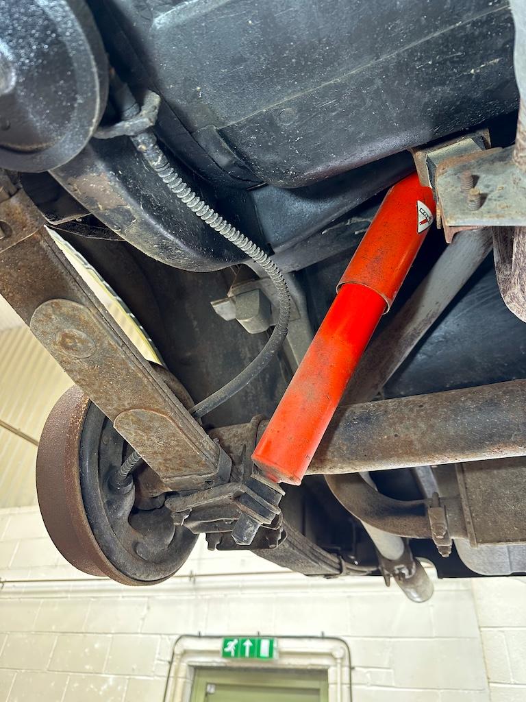 Rear leaf springs & shocks – Surface corrosion across the leaf spring and mounting bracket. Brake drum showing oxidation. Shock paint good.