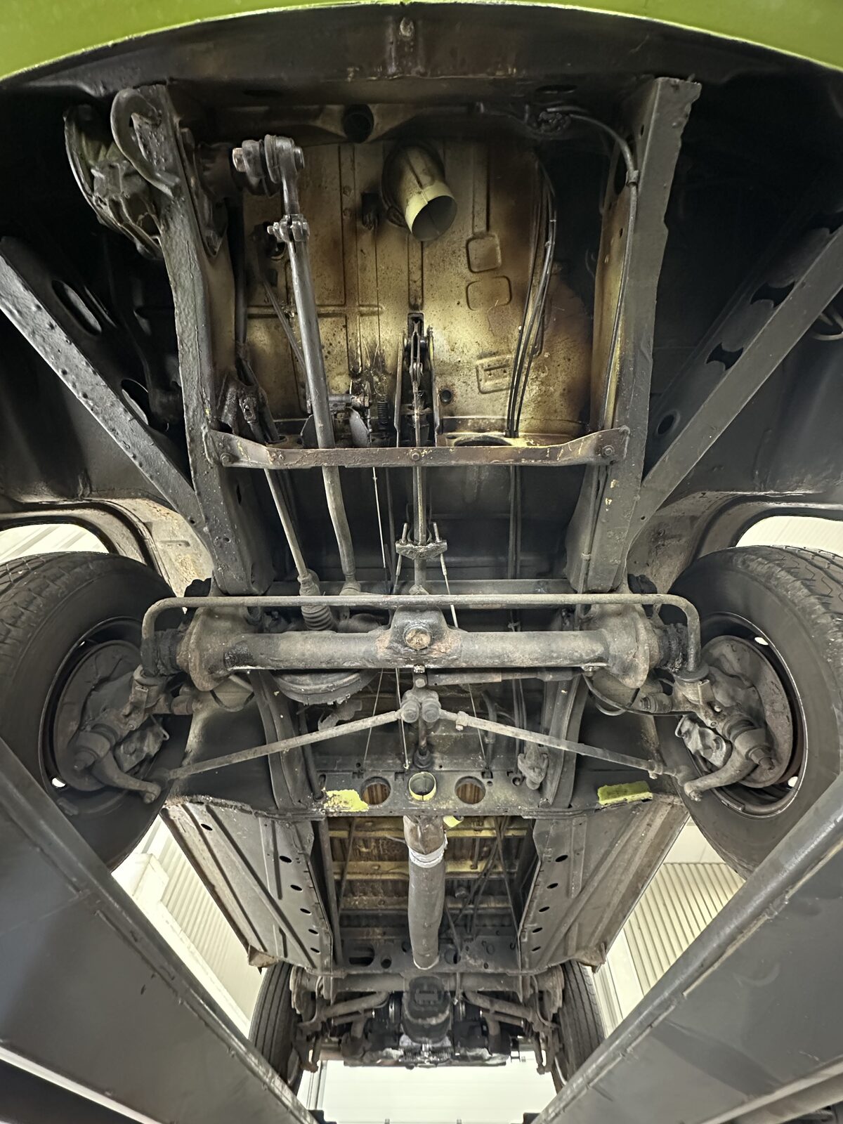 Full underbody – Decades of road grime, old underseal and surface corrosion across the floor pans, chassis members and running gear – the underside of a camper that has earned its keep.