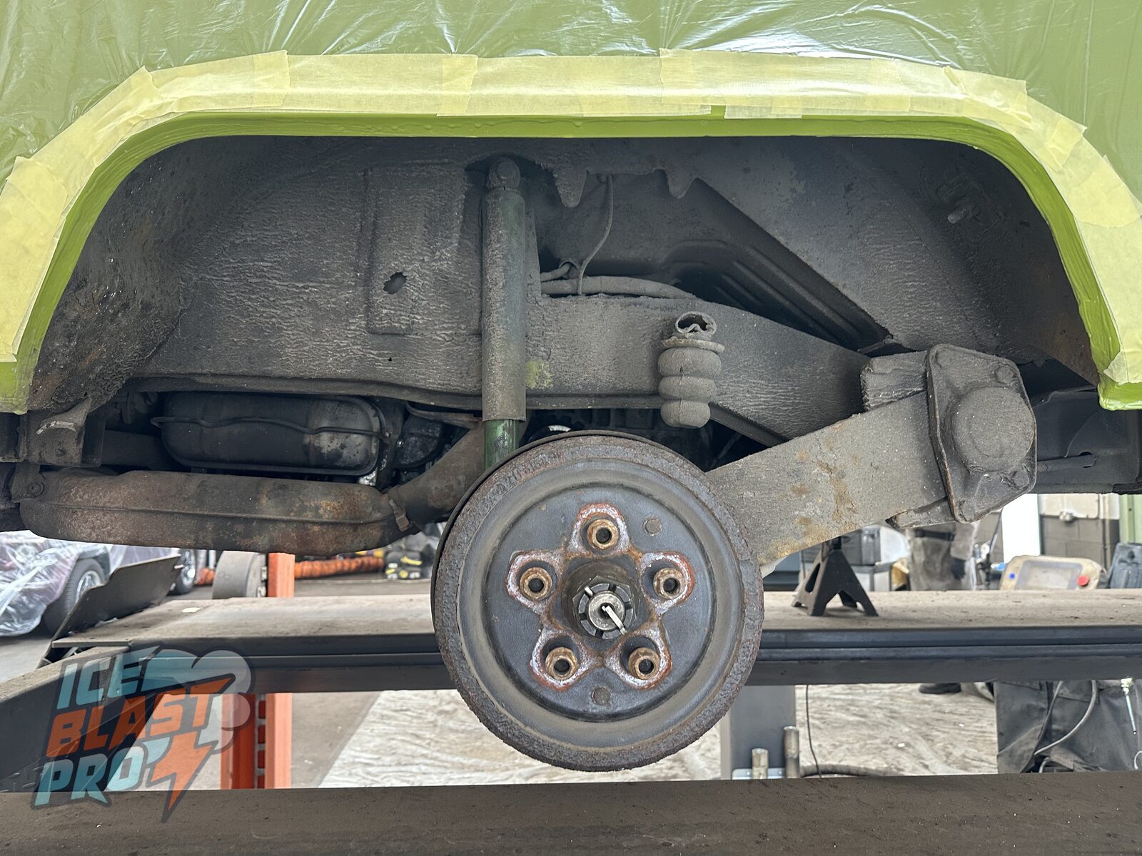 Rear arch & brake drum – Grime and corrosion packed around the rear wheel arch, brake drum and suspension, with the body masked off ready for cleaning.