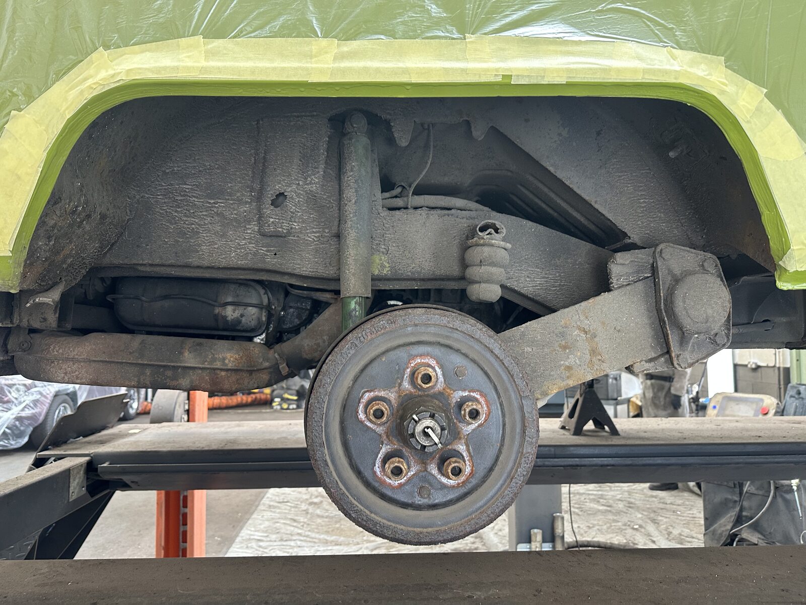 Rear arch & brake drum – Grime and corrosion packed around the rear wheel arch, brake drum and suspension, with the body masked off ready for cleaning.