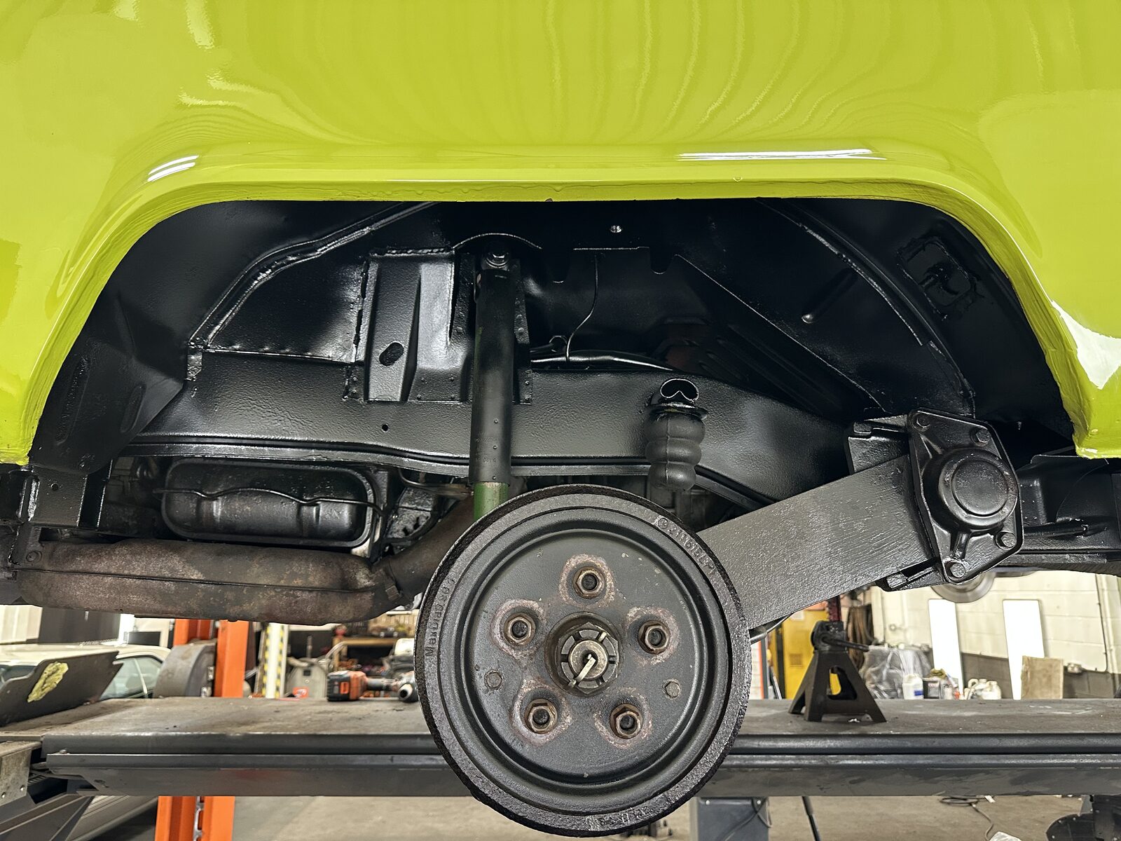 Wheel arch & drum – The arch, brake drum and suspension cleaned, treated and protected, sitting under the camper's restored original green paint.